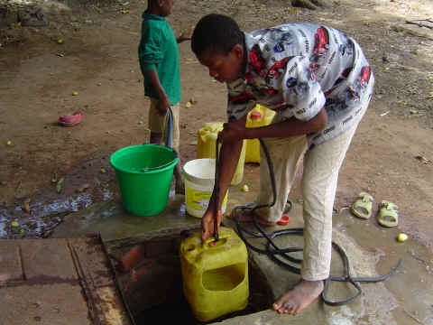 Ce jeune-homme sort l'eau du puits. On distingue les puits pour l'eau de boisson des puits pour la lessive.