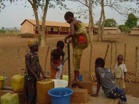 Des enfants pompent l'eau du forage